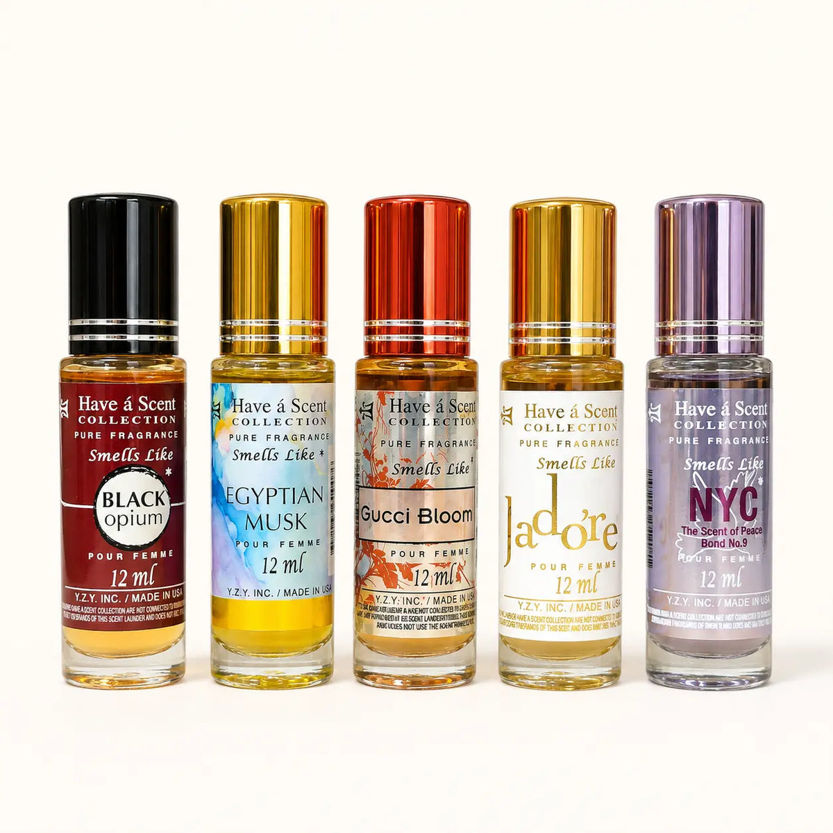 Five small roll-on perfume bottles from Have & Scent Collection lined up on a white background, featuring different scents: Black Opium, Egyptian Musk, Gucci Bloom, J'adore, and Smells Like NYC.