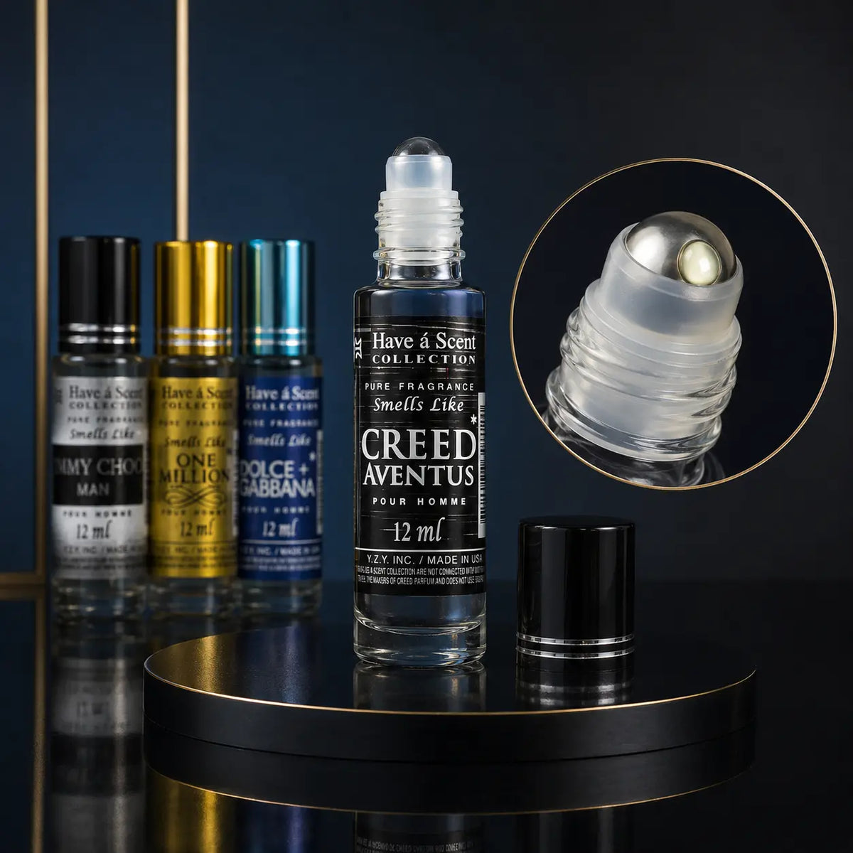 A clear glass roll-on perfume bottle labeled Creed Aventus from Have & Scent Collection, displayed on a black circular pedestal with its black cap beside it. Three additional fragrance bottles in gray, gold, and blue stand in the background, and a circular inset shows the rollerball tip detail.