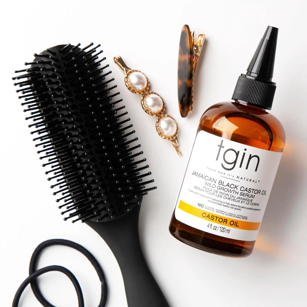 TGIN Jamaican Black Castor Oil Growth Serum 4 oz — serum bottle with brush and hair clips