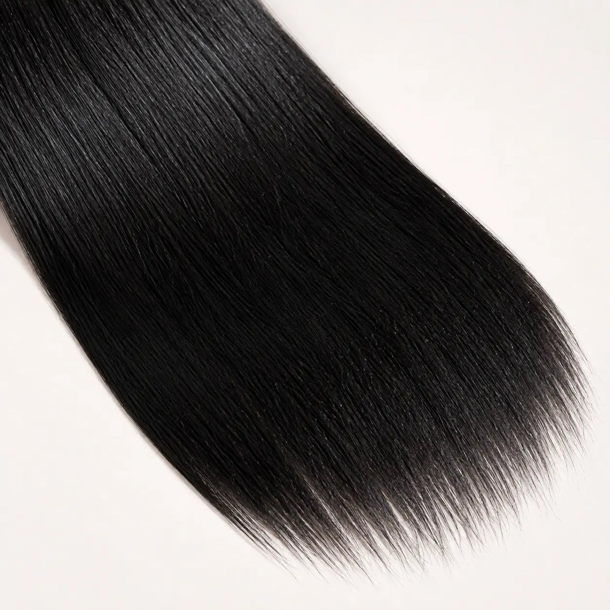 A close-up of straight, glossy black hair strands against a plain white background.