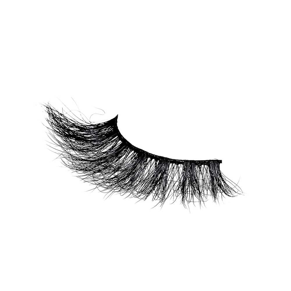 VLEC03_extra_004 "A package of false eyelashes. The packaging is transparent, allowing the eyelashes to be clearly visible. The eyelashes are thick and voluminous, with a slightly curled design. The brand name "V Luxe by i-Envy" is printed on the packaging, along with the style name "Velvet Rose." The background inside the packaging has a subtle, glittery texture."