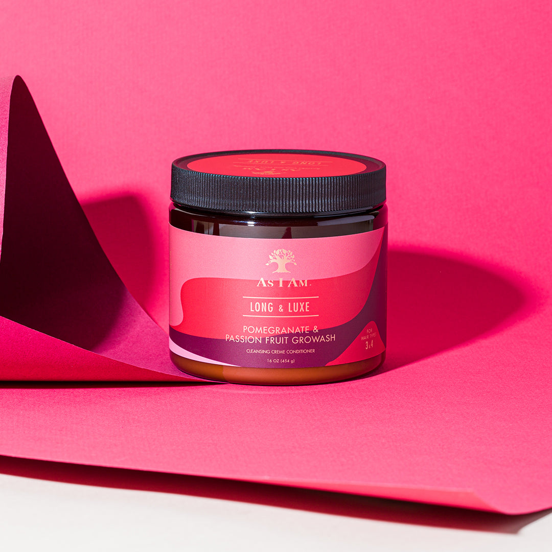 A jar of As I Am Long & Luxe Growash placed on a bright pink background.