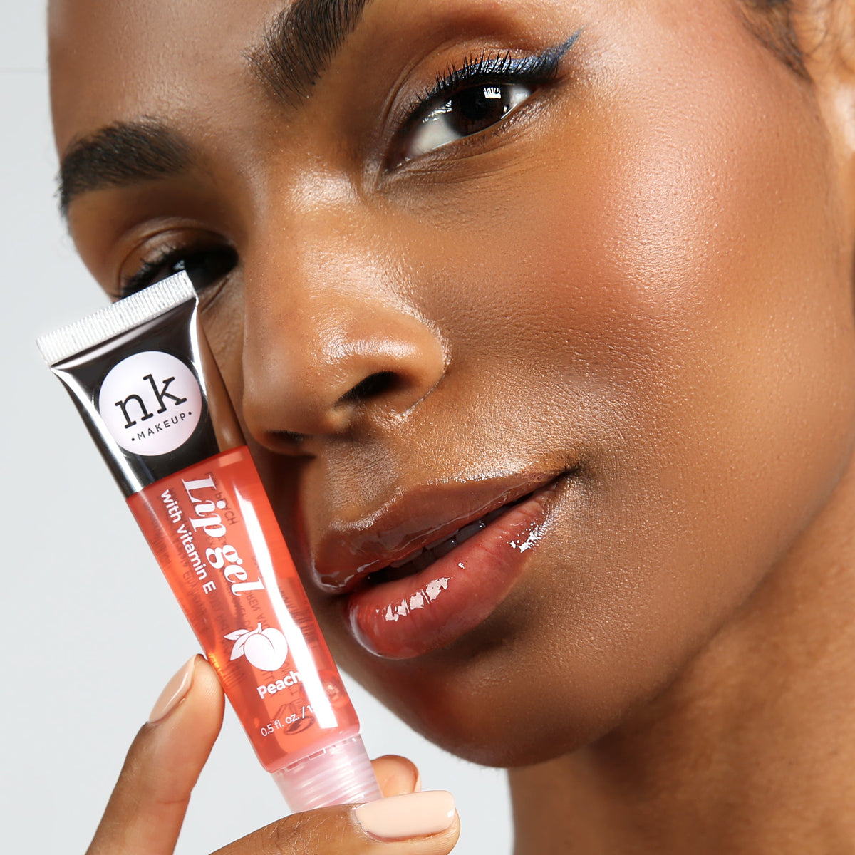 Nicka K Lip Gel, model holding Peach gloss