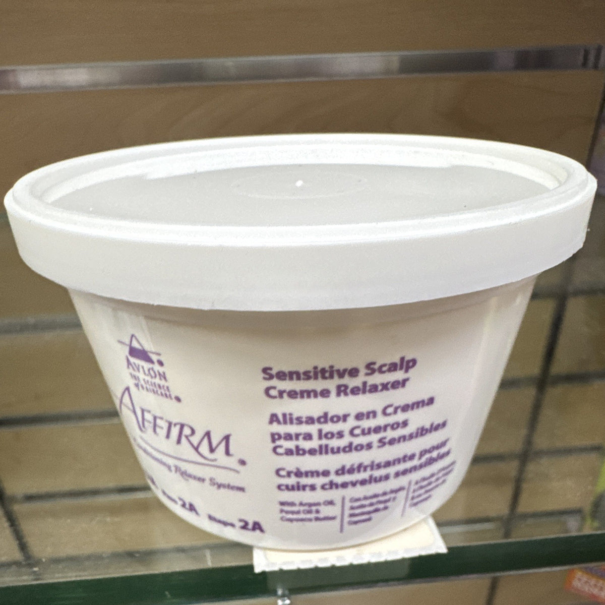 White plastic bucket with a lid labeled “Affirm Sensitive Scalp Creme Relaxer” in white text with purple logo on the side.