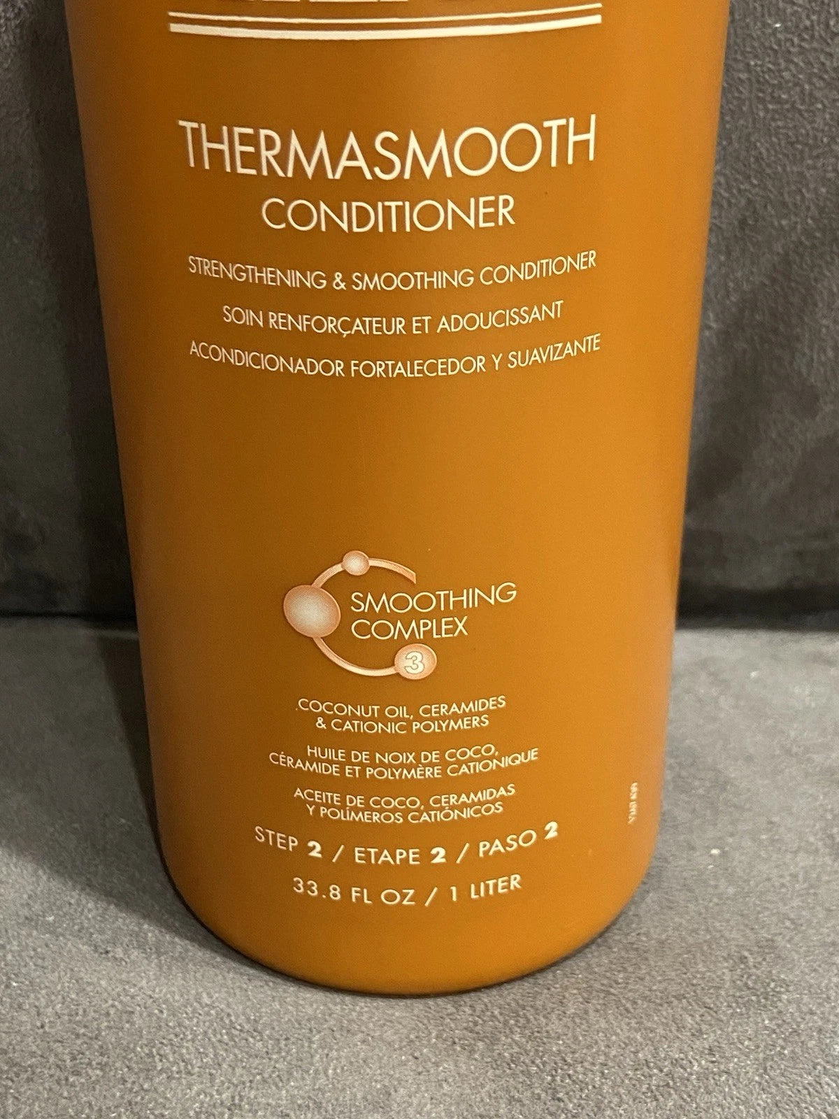 Orange MIZANI Thermosmooth Conditioner bottle with white text, product image, and “Smoothing Complex” label.